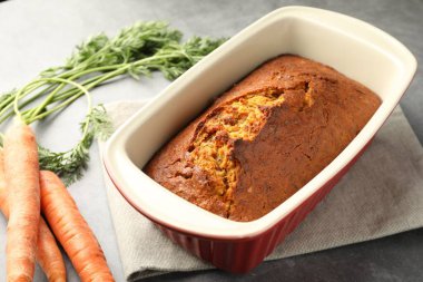 Gri desenli masada havuçlu kek ve sebzeler, yakın plan.