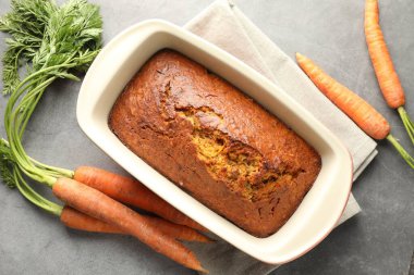 Lezzetli havuçlu kek ve sebzeler gri desenli masada, düz yatıyordu.