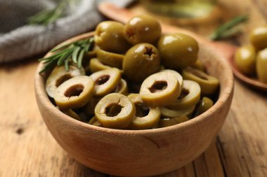 Tahta masadaki kasede zeytin halkaları, yakın plan.