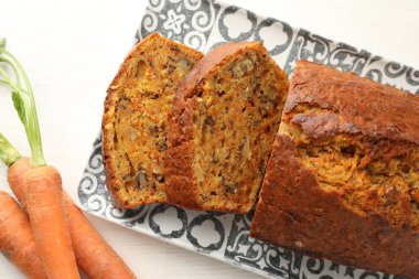 Beyaz ahşap masada fındıklı ve sebzeli ev yapımı havuçlu kek.