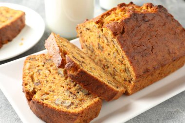 Ev yapımı havuçlu kek, fındıklı ve sütlü gri masa, yakın plan.