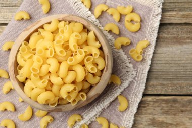 Tahta masadaki kasede çiğ boynuzlu makarna, üst manzara. Metin için boşluk