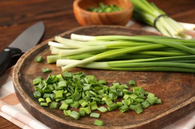 Taze yeşil soğan ve bıçak masanın üstünde, yakın plan.