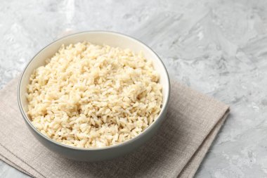 Gri desenli masada servis edilen lezzetli kahverengi pirinç, yakın plan. Metin için boşluk