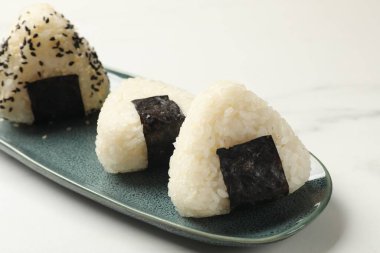 Pirinç topları (onigiri) ışık masasında, yakın plan. Geleneksel Japon yemeği