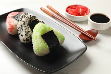 Lezzetli tobiko onigiri (Japon pirinç topları) beyaz masada servis edilir.