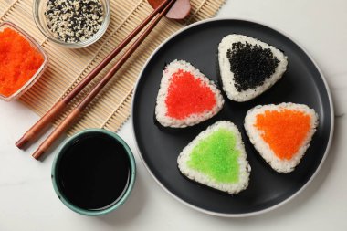 Lezzetli tobiko onigiri (Japon pirinç topları) beyaz mermer masada servis edilir.