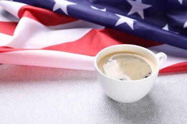 Bir fincan kahve ve Amerikan bayrağı ışık masasında. Metin için boşluk