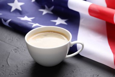 Bir fincan kahve ve siyah masada Amerikan bayrağı, yakın plan.