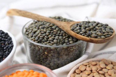 Beyaz masada farklı türde mercimek, yakın plan.