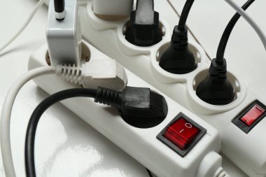Uzatma güç panoları ahşap zemindeki tıkaçlarla aşırı yüklenmiş, yakın plan.
