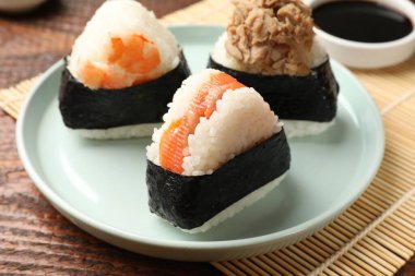 Lezzetli onigiri (Japon pirinç topları) ahşap masada servis edilir, yakın plan.