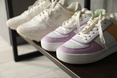 Ayakkabı deposu. Farklı ayakkabı giyimli raf ünitesi, yakın plan.