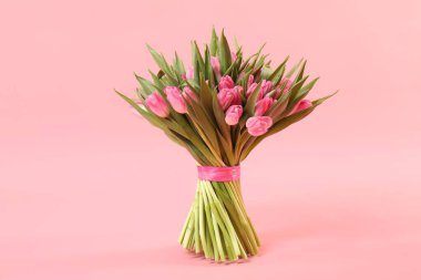 Bouquet of beautiful tulips on pink background