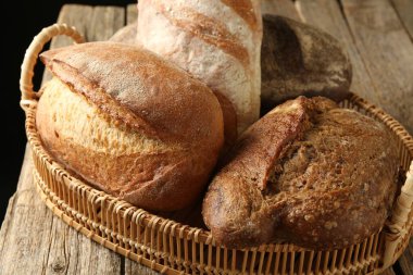 Tahta masadaki sepetin içinde farklı somunlar, yakın çekim.