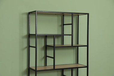 İçerideki zeytin duvarının yanındaki boş ahşap raf ünitesi.