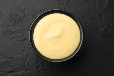 Lezzetli peynir sosu siyah masada, üst tarafta.