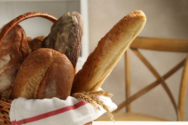 Farklı somunlar taze ekmek ve hasır sepetin içinde kapalı masa, yakın çekim