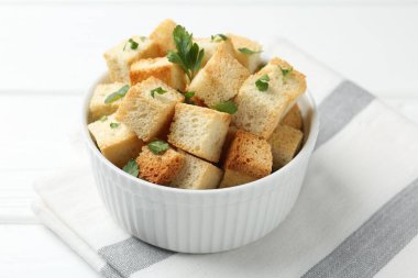 Beyaz ahşap masada maydanozlu çıtır çıtır kızarmış ekmek.