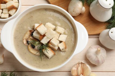 Lezzetli mantar kremalı çorba, kızarmış ekmek, dereotu ve malzemeler beyaz ahşap masa üzerinde, düz yatıyordu.