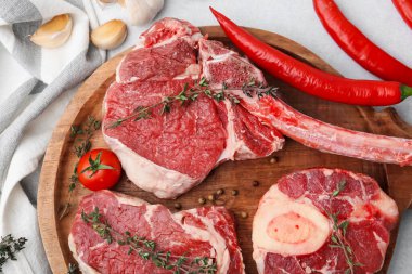 Çiğ et parçaları, baharatlar ve ürünler açık gri masa üzerinde, düz yatıyordu.