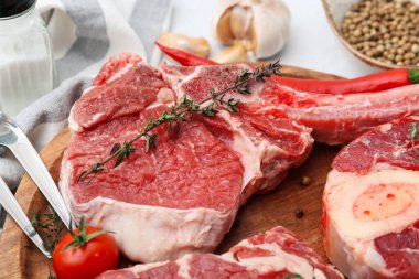 Çiğ et, domates ve baharatlar beyaz masada, yakın plan.