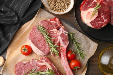 Çiğ et parçaları, domates ve baharatlar ahşap masada, düz yatıyordu.