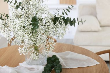 Güzel çigila çiçekleri ve okaliptüs dallarıyla dolu bir vazo.