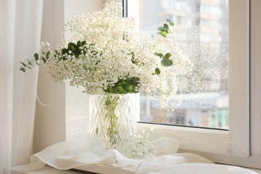 Güzel çigila çiçekleri ve okaliptüs dallarıyla dolu bir vazo.