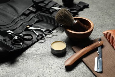 Gri desenli masada birçok farklı berber aleti var. Yakın plan.