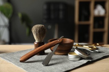 Berber dükkanında, açık ahşap masanın üzerinde birçok farklı berber aleti var.