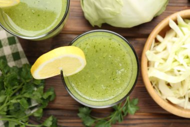 Sağlıklı maydanoz bardakta, limonda, lahanada, ahşap masada.