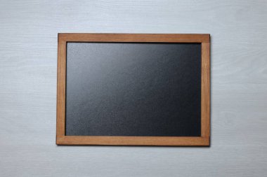 Hafif ahşap zemin üzerinde boş küçük karatahta, üst görünüm