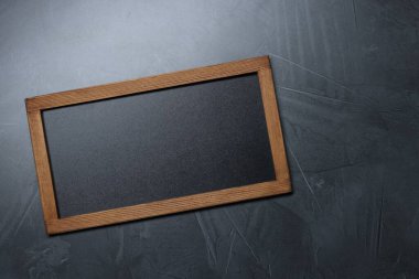 Koyu gri arkaplan üzerine boş küçük karatahta, üst görünüm