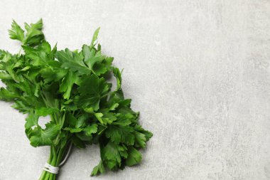 Bir demet taze maydanoz, gri desenli masa, üst manzara. Metin için boşluk