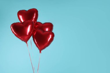 Açık mavi arka planda bir sürü kırmızı kalp şeklinde balon, yazı için boşluk. Sevgililer Günün kutlu olsun.