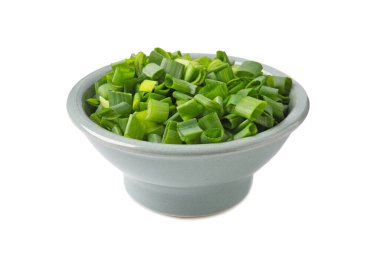 Taze doğranmış yeşil soğan beyaz kasede izole edilmiş.