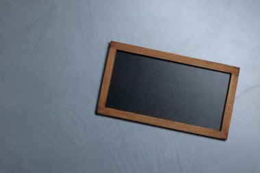 Gri desenli arka planda boş küçük karatahta, üst görünüm. Metin için boşluk