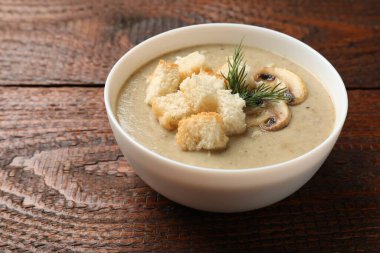 Ekmek arası mantar kremalı çorba ve ahşap masada dereotu, yakın plan.