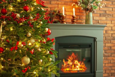 Evdeki şöminenin yanında güzel dekore edilmiş Noel ağacı, yakın çekim. Metin için boşluk
