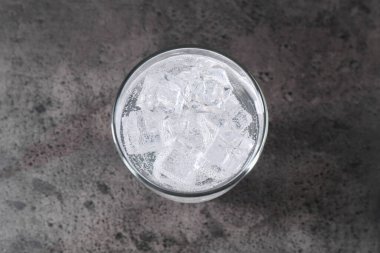 Gri masadaki buzlu buzlu soda tazeleniyor.