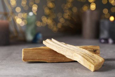 Palo Santo, bulanık ışıklara karşı gri masaya yapışıyor.