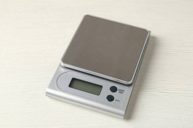 Beyaz ahşap masada elektronik mutfak terazisi.