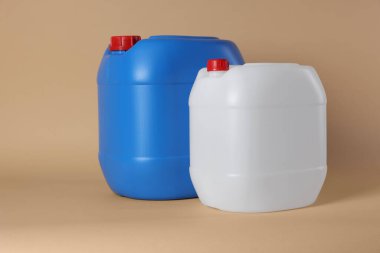 Two clean plastic canisters on beige background