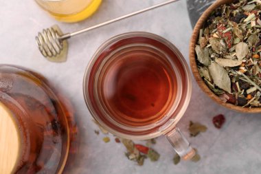 Gri masa üzerinde bal ve kuru yapraklı lezzetli bitkisel çay.
