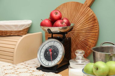 Kitchen scale, products and cooking utensils on wooden table