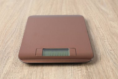 Modern elektronik mutfak terazisi ahşap masa, yakın plan.