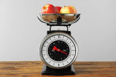 Retro mechanical kitchen scale with apples on wooden table