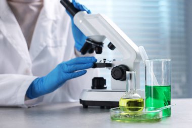 Biyokimya. Laboratuvarda, gri masada bitki ve sıvılarla çalışan bilim adamı.