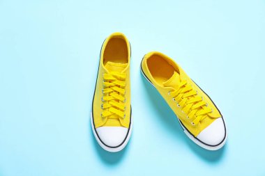 Sarı arka planda bir çift şık spor ayakkabı, düz. Spor ayakkabılar.